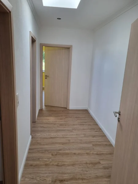 Renovierter Flur und Treppenaufgang mit neuem Designboden und frischem Wandanstrich in Kappeln