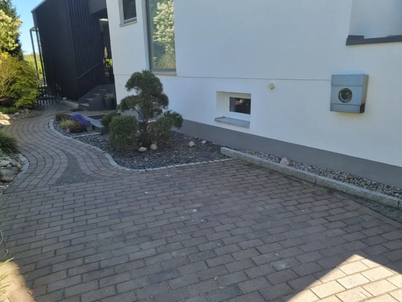 Gestrichene Fassade an der Einfahrt mit Kellerfenster und Briefkasten