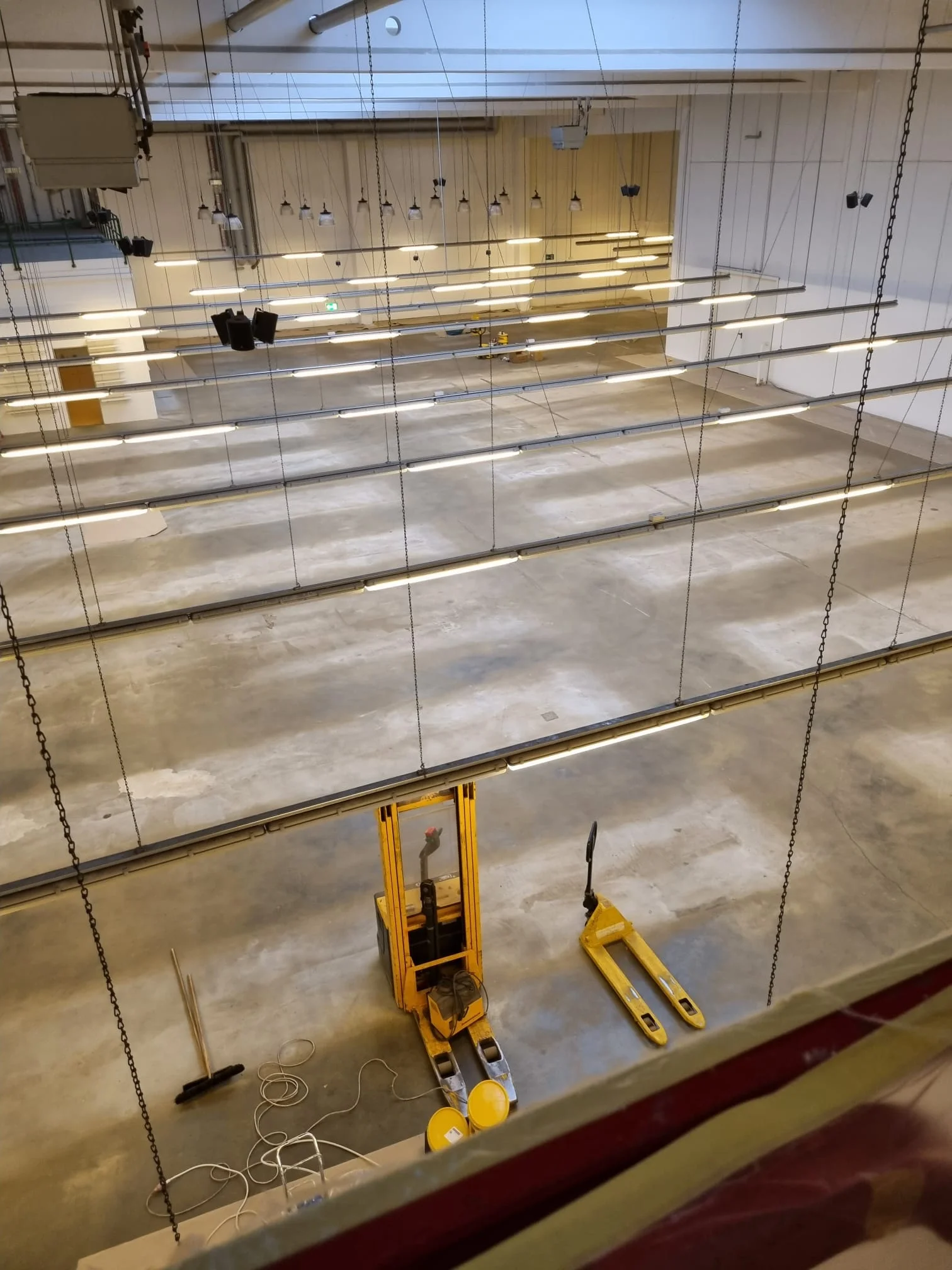 Blick von der Galerie auf frisch weiß gespritzte Hallenwände in Lagerhalle Gönnebek