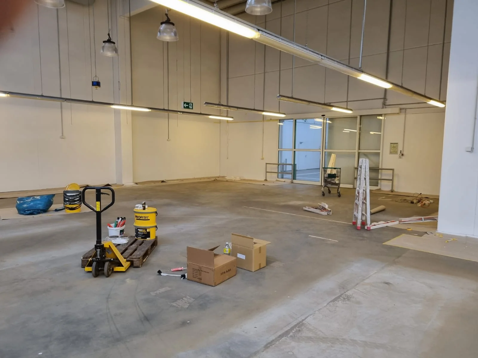 Farbeimer und Malerausrüstung für Wandanstrich in Lagerhalle Gönnebek