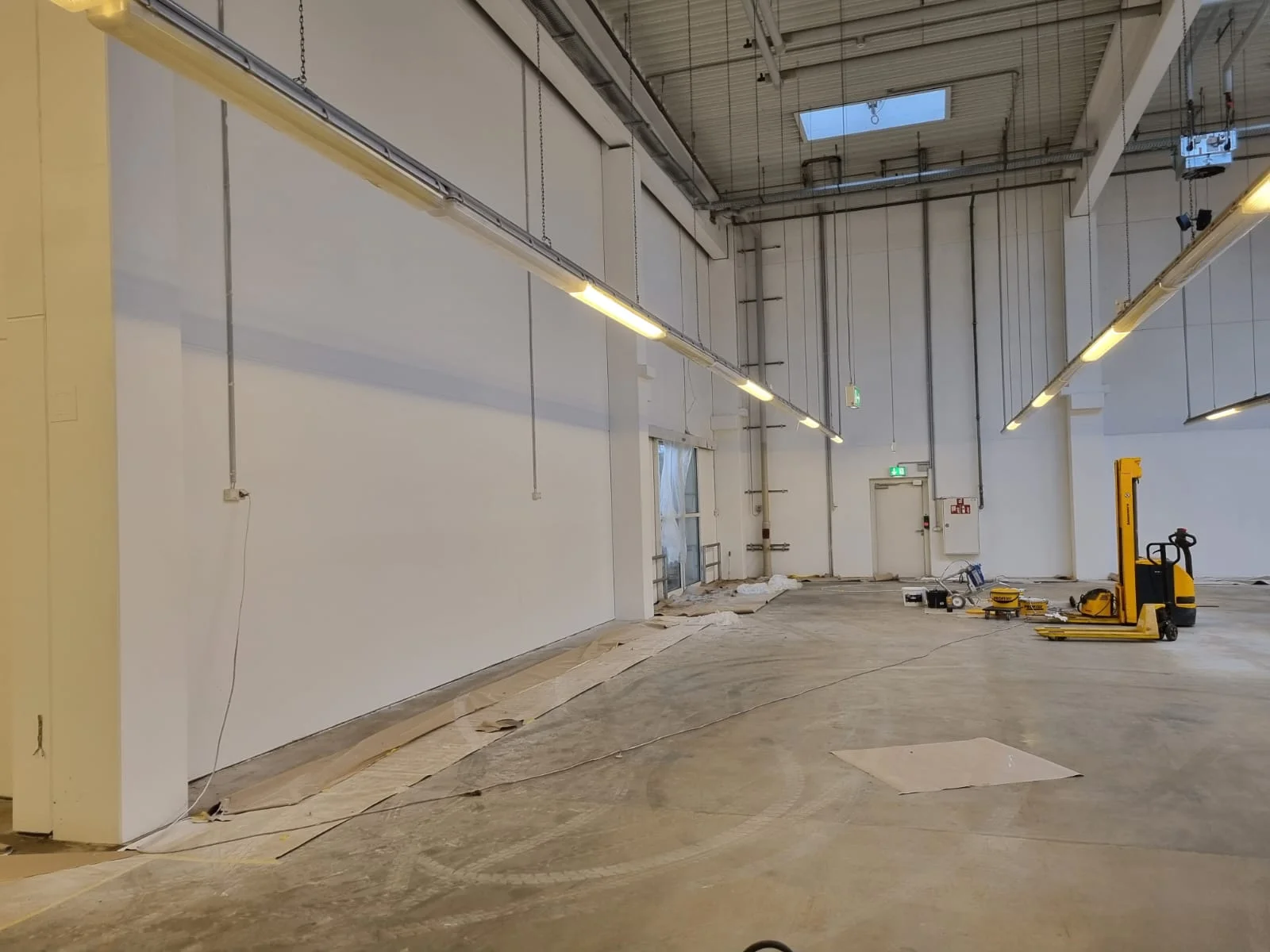 Weiß gespritzte Lagerhalle mit hohen Wänden von AM Raumdesign S-H in Gönnebek