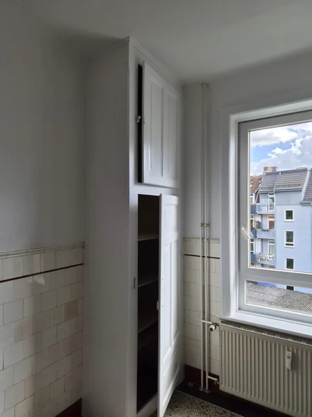 Weiß lackierter Einbauschrank und frisch gestrichene Wände in der Küchennische
