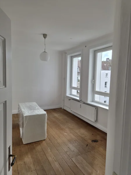 Frisch gestrichenes Zimmer mit weiß lackiertem Heizkörper unter der Fensternische
