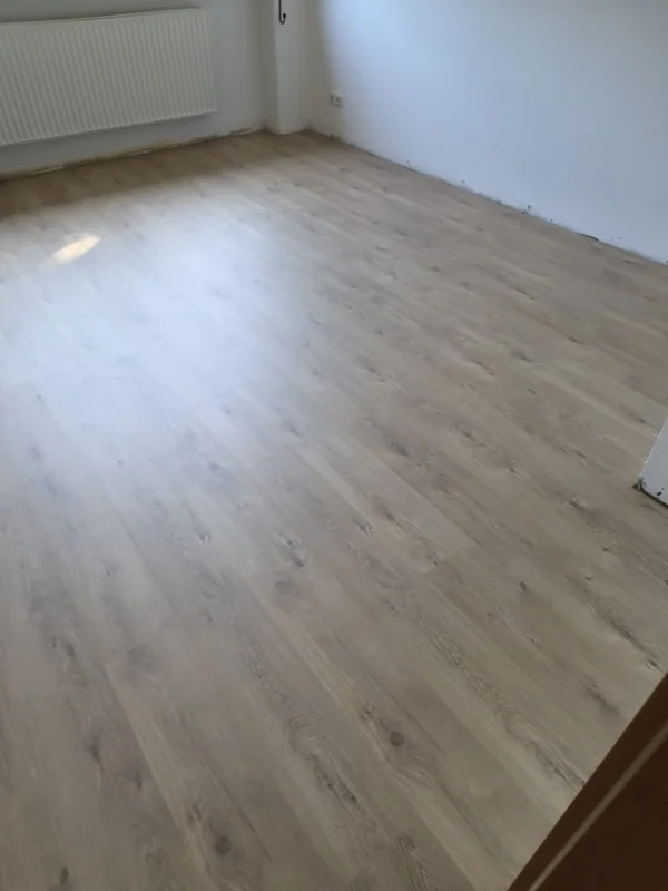 Ein Wohnraum nach Abschluss der Arbeiten, neues Laminat komplett verlegt und die Wände frisch gestrichen
